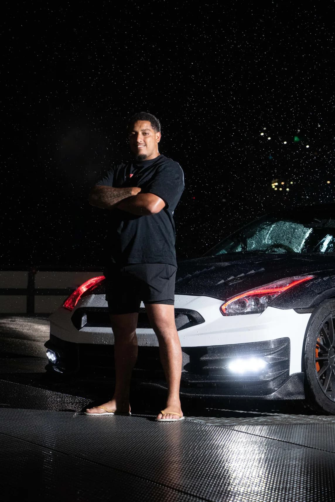 San - Your Driver & Guide standing with GT-R at night